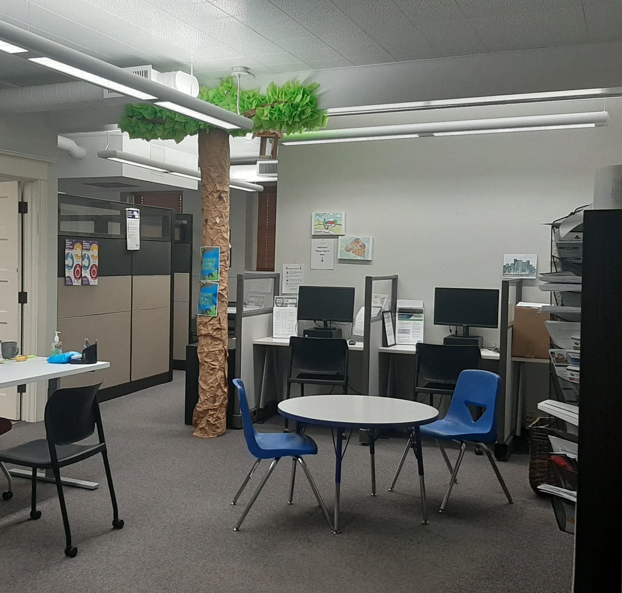 The Housing Navigation Center room with computer stations, resource racks and a kids' corner